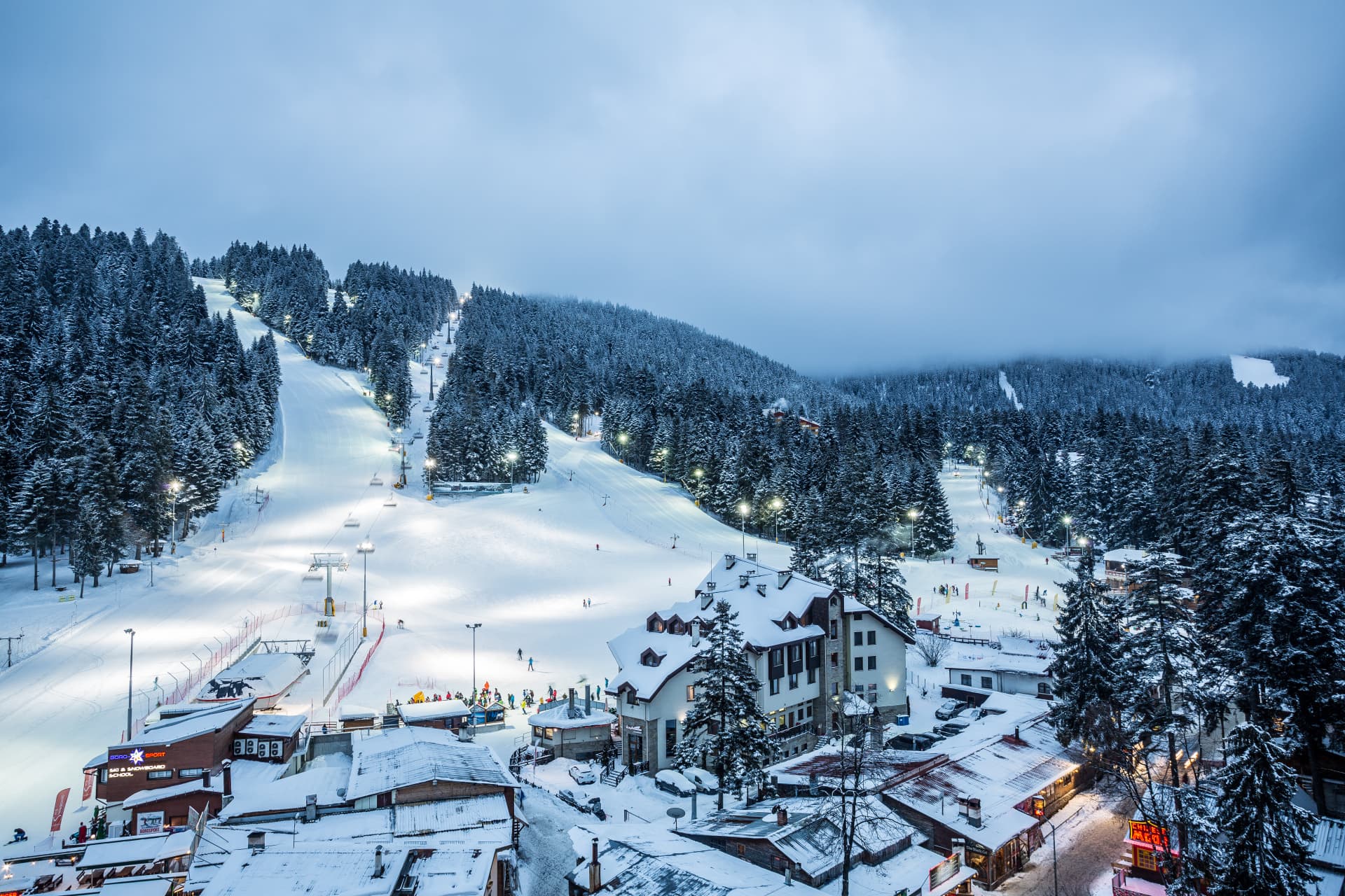 Skiiers enjoying Borovets slopes under floodlights at night in Bulgaria